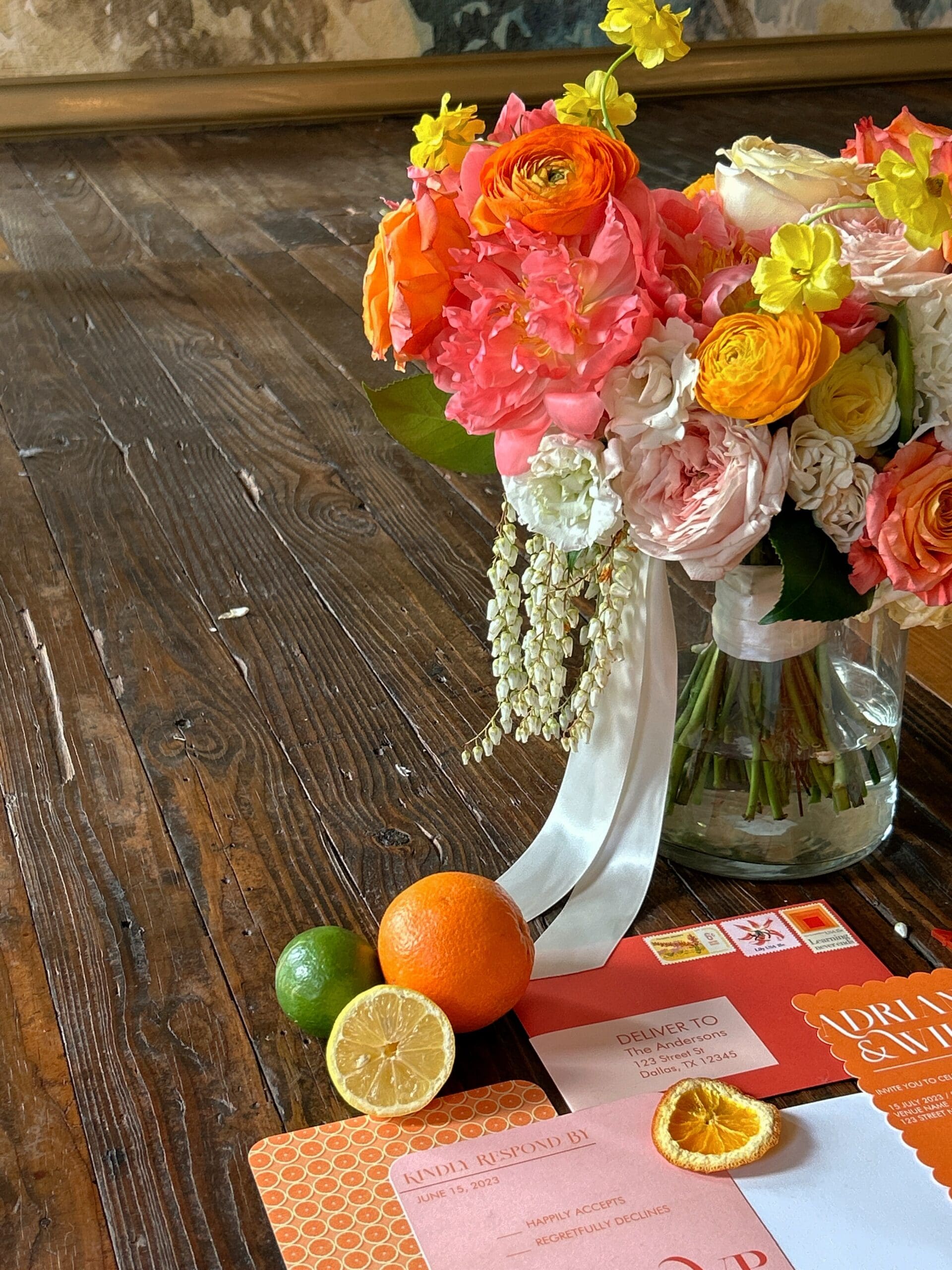 Colorful flower vasae with bright wedding invitation suite in front